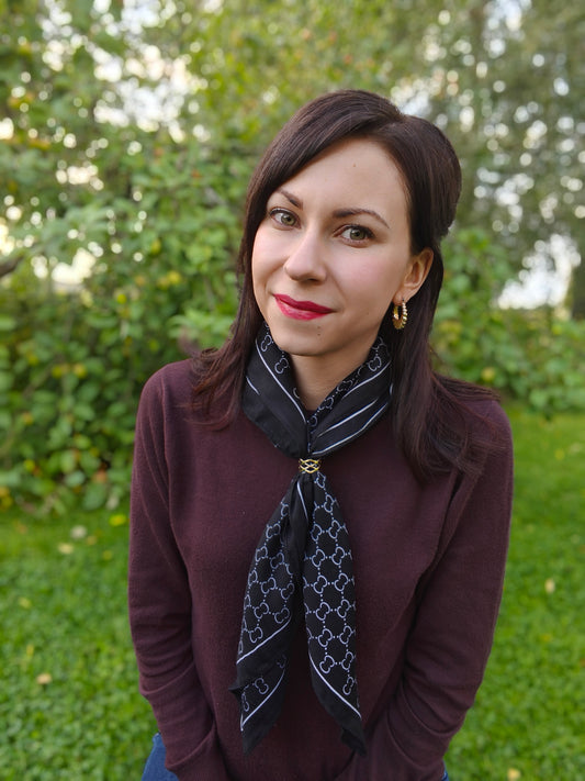 Naisella huivi kiinnitettynä huivirenkaalla eli scarf ringillä.